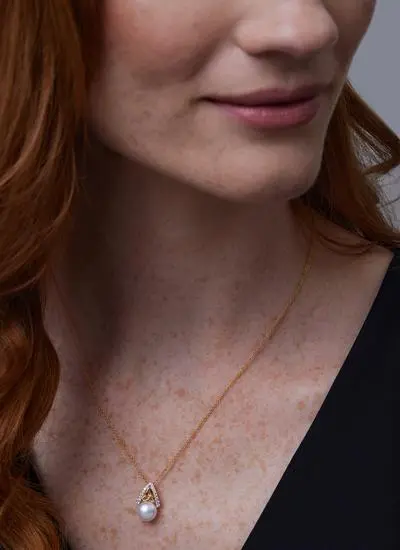 Close up shot of red haired model wearing 14Ct Gold Vermeil Trinity Knot Pearl Pendant with White Cubic Zirconia